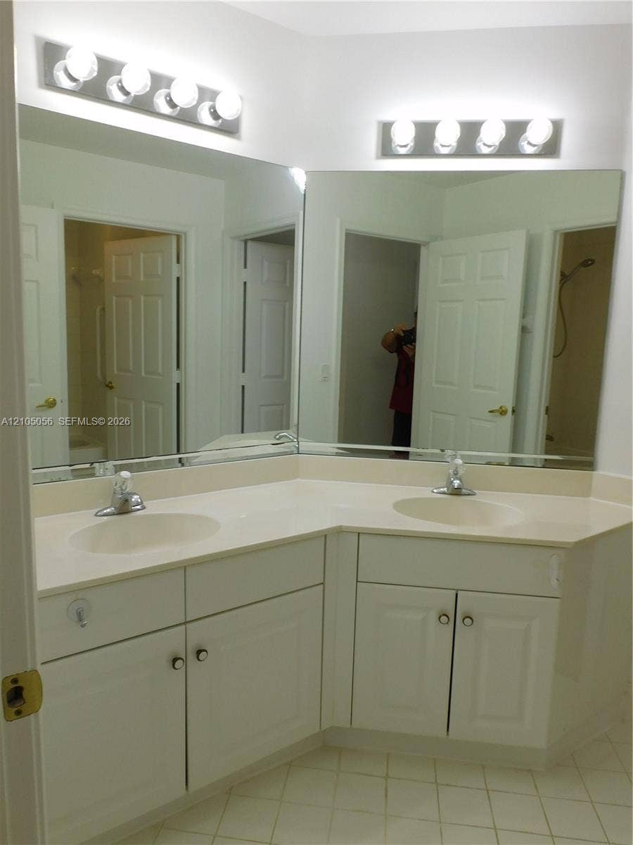 16729 Amber Lake, Weston, FL 33331 Dual vanity with integrated sinks, expansive counter space, white cabinetry, and overhead lighting fixtures