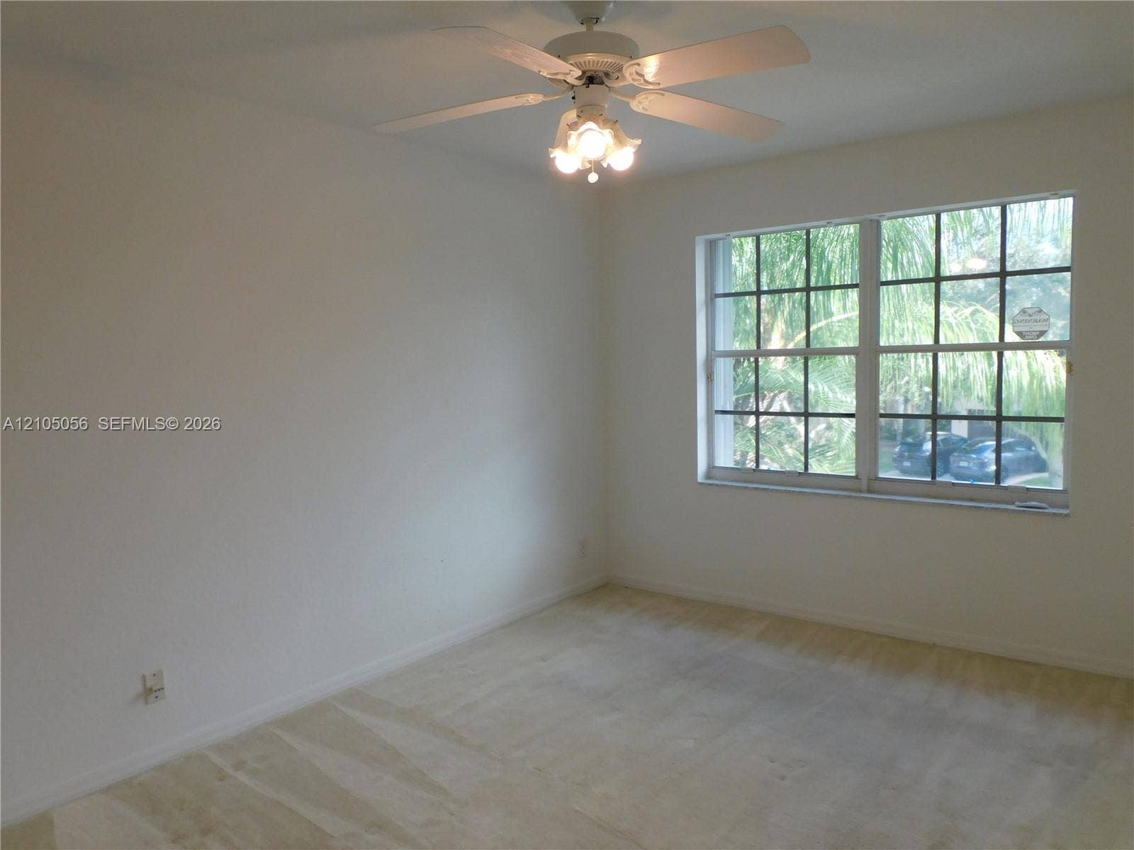 16729 Amber Lake, Weston, FL 33331 Neutral wall paint, ceiling fan with integrated lighting, grid-pattern window, and carpet flooring