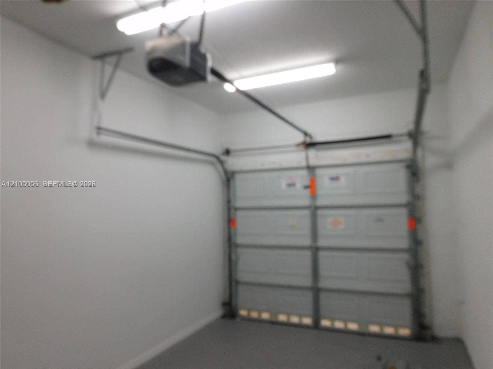 16729 Amber Lake, Weston, FL 33331 Garage space with an automatic garage door opener and two overhead fluorescent light fixtures