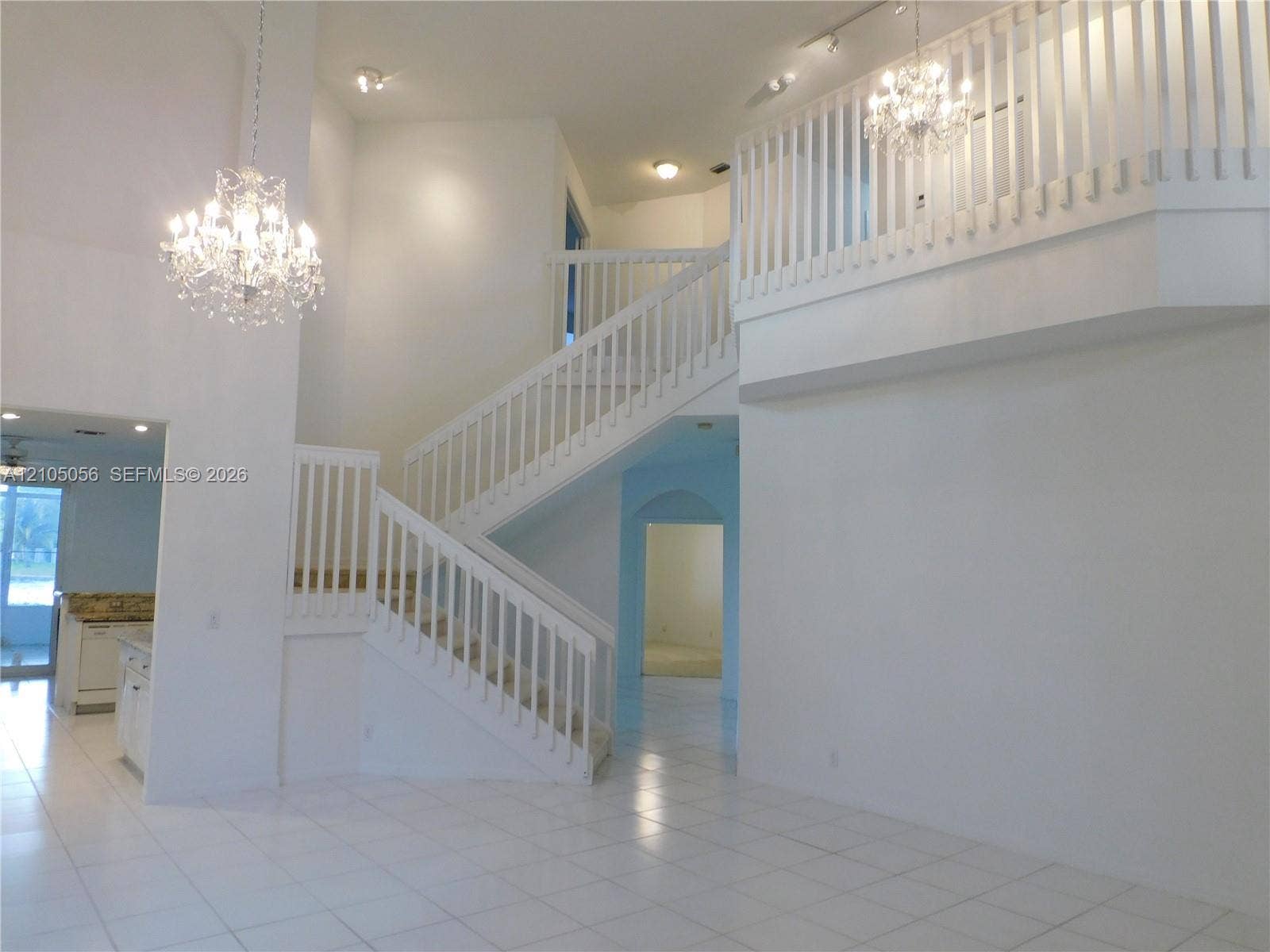 16729 Amber Lake, Weston, FL 33331 Two-story foyer featuring a double staircase with white balusters, two crystal chandeliers, and loft overlooks social areas - loft is an added bonus to easily suit your needs.