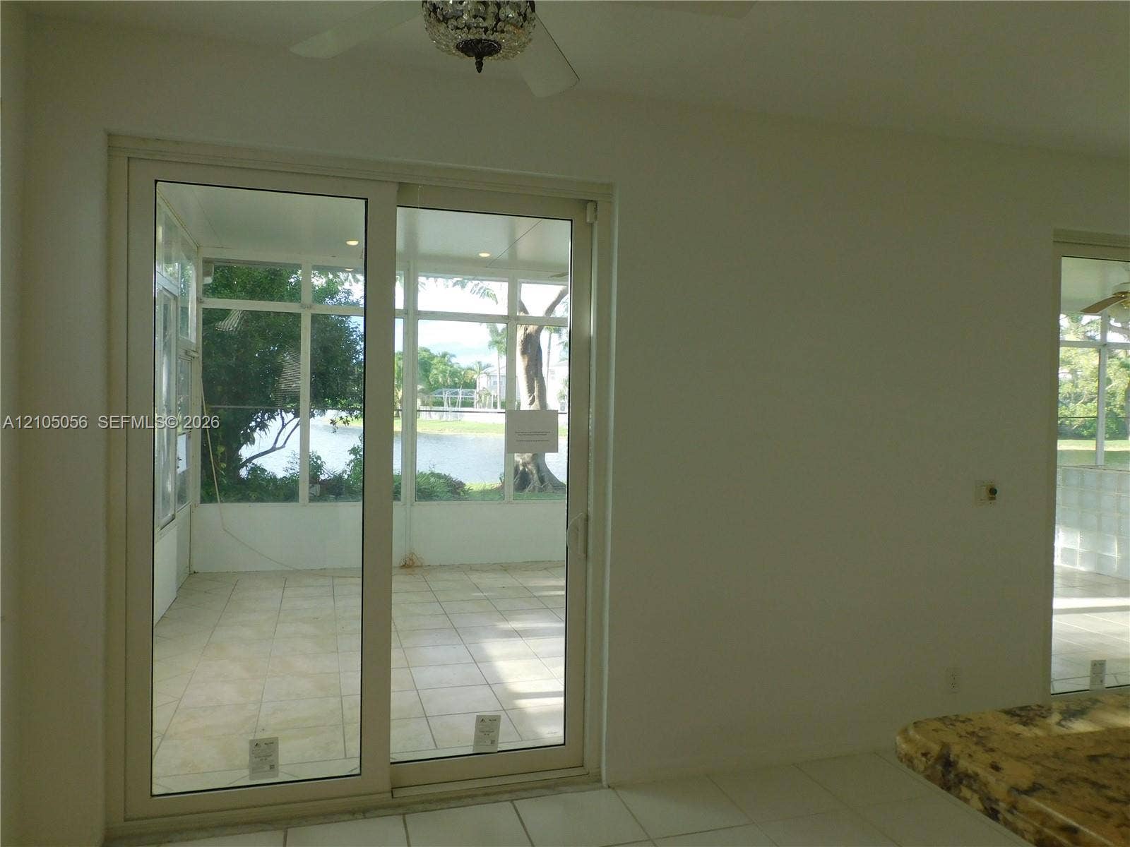16729 Amber Lake, Weston, FL 33331 Sliding glass door leading to a screened lanai with tiled flooring