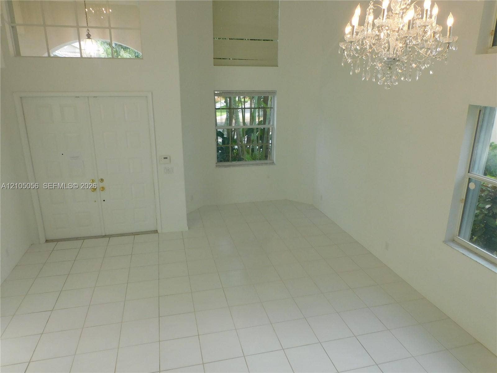 16729 Amber Lake, Weston, FL 33331 Double entry doors with gold-tone hardware, tile flooring, and a crystal chandelier