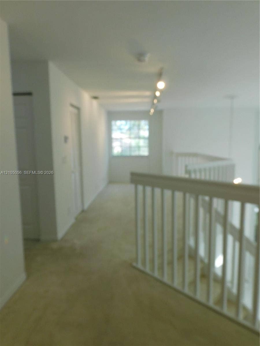 16729 Amber Lake, Weston, FL 33331 Second-level landing with carpet flooring, white painted walls, and track lighting - you can make it to suit your needs.