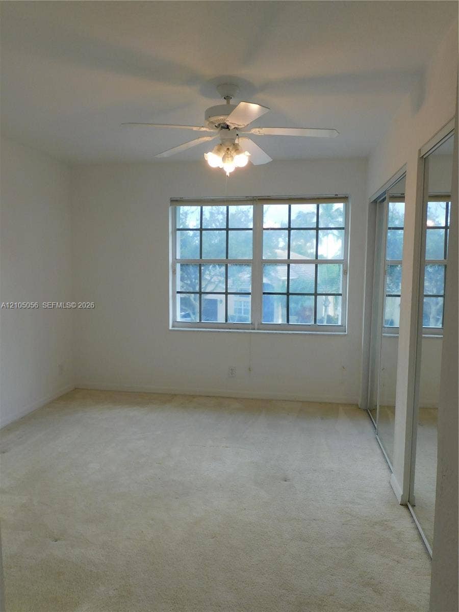 16729 Amber Lake, Weston, FL 33331 Recessed window with grid pattern, overhead ceiling fan with integrated lighting, and mirrored sliding closet doors