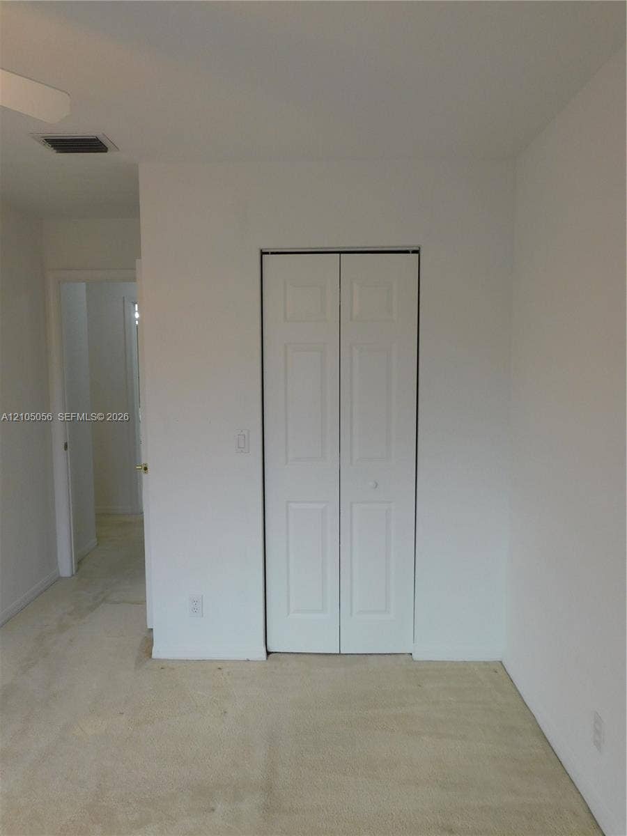 16729 Amber Lake, Weston, FL 33331 Bi-fold closet doors, wall-to-wall carpeting, and a ceiling-mounted fan