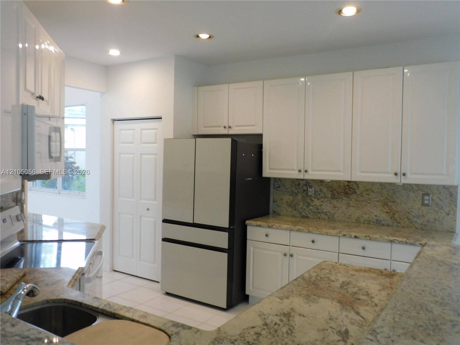 16729 Amber Lake, Weston, FL 33331 Kitchen featuring light-toned cabinetry, granite countertops, pantry and plenty of cabinet space.