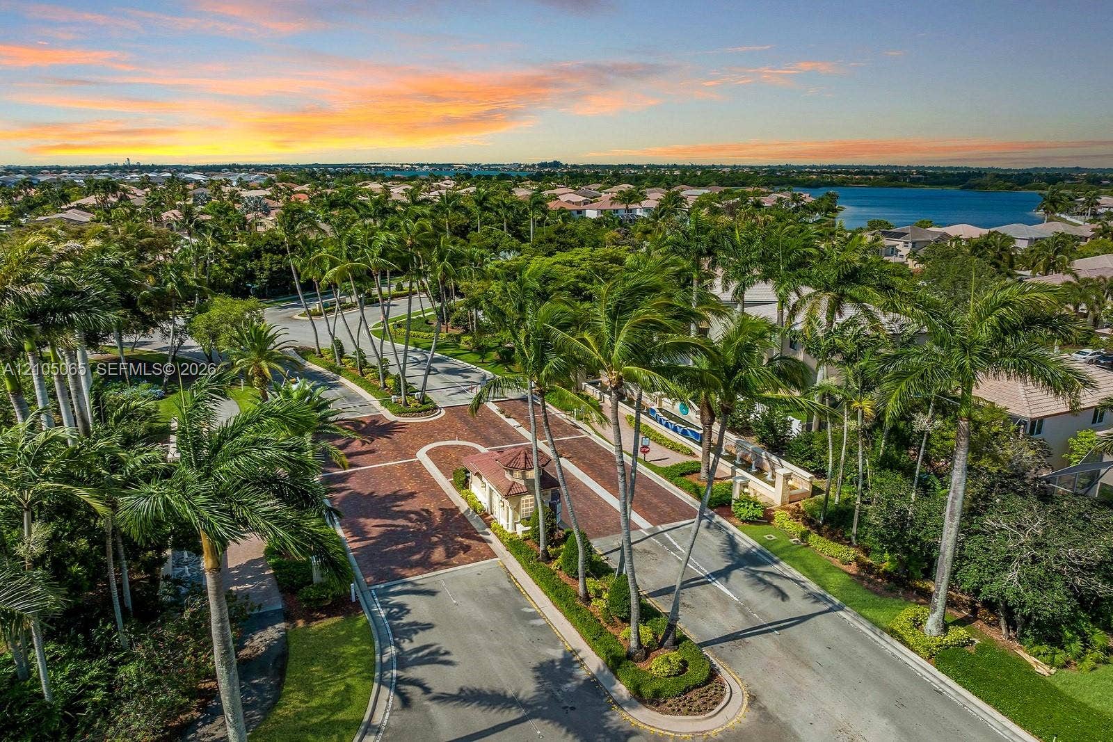 17621 SW 4th Court, Pembroke Pines, FL 33029 Gated community entrance featuring paver-accented roadways, mature palm tree landscaping, and a central security pavilion