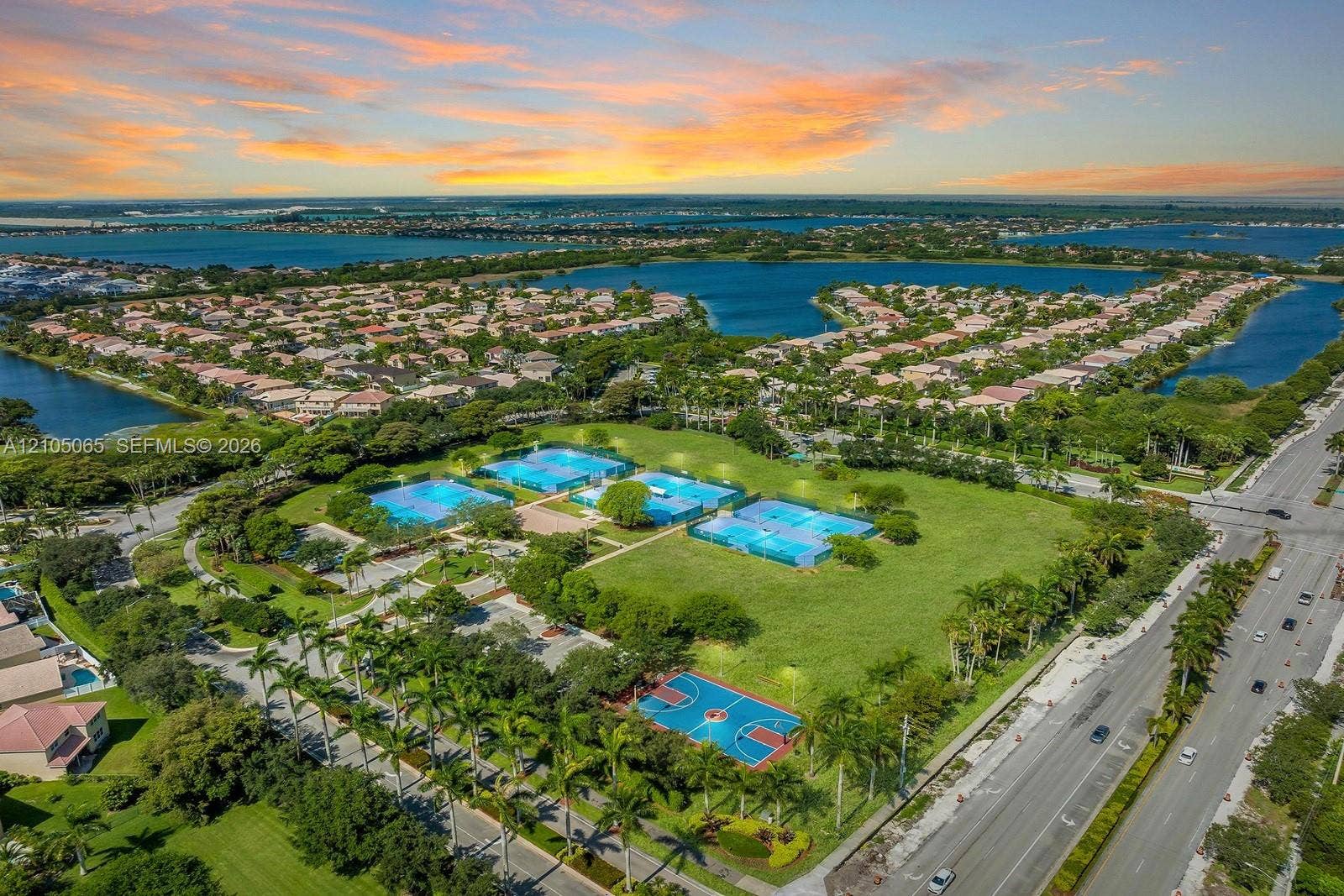 17621 SW 4th Court, Pembroke Pines, FL 33029 Aerial perspective of a recreational complex featuring multiple tennis courts, a basketball court, expansive green space, and mature palm trees