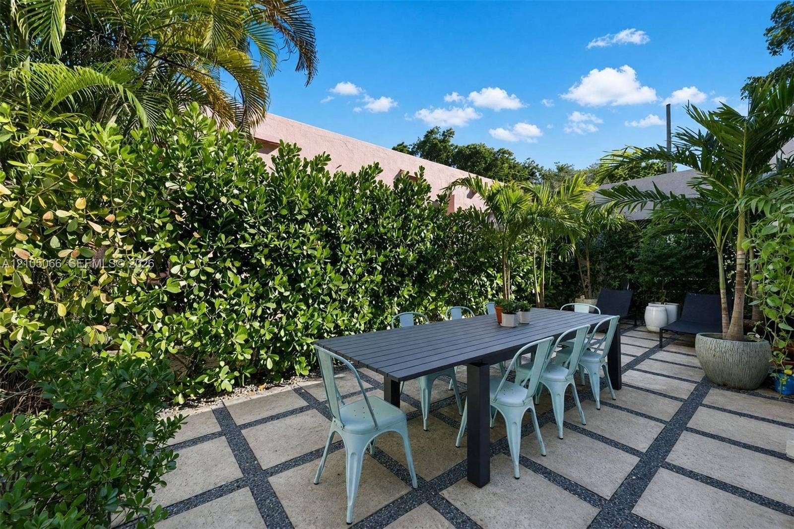 1230 Genoa Street, Coral Gables, Coral Gables, FL 33134 Rear patio featuring large-format stone pavers, geometric gravel inlay, and established perimeter hedges