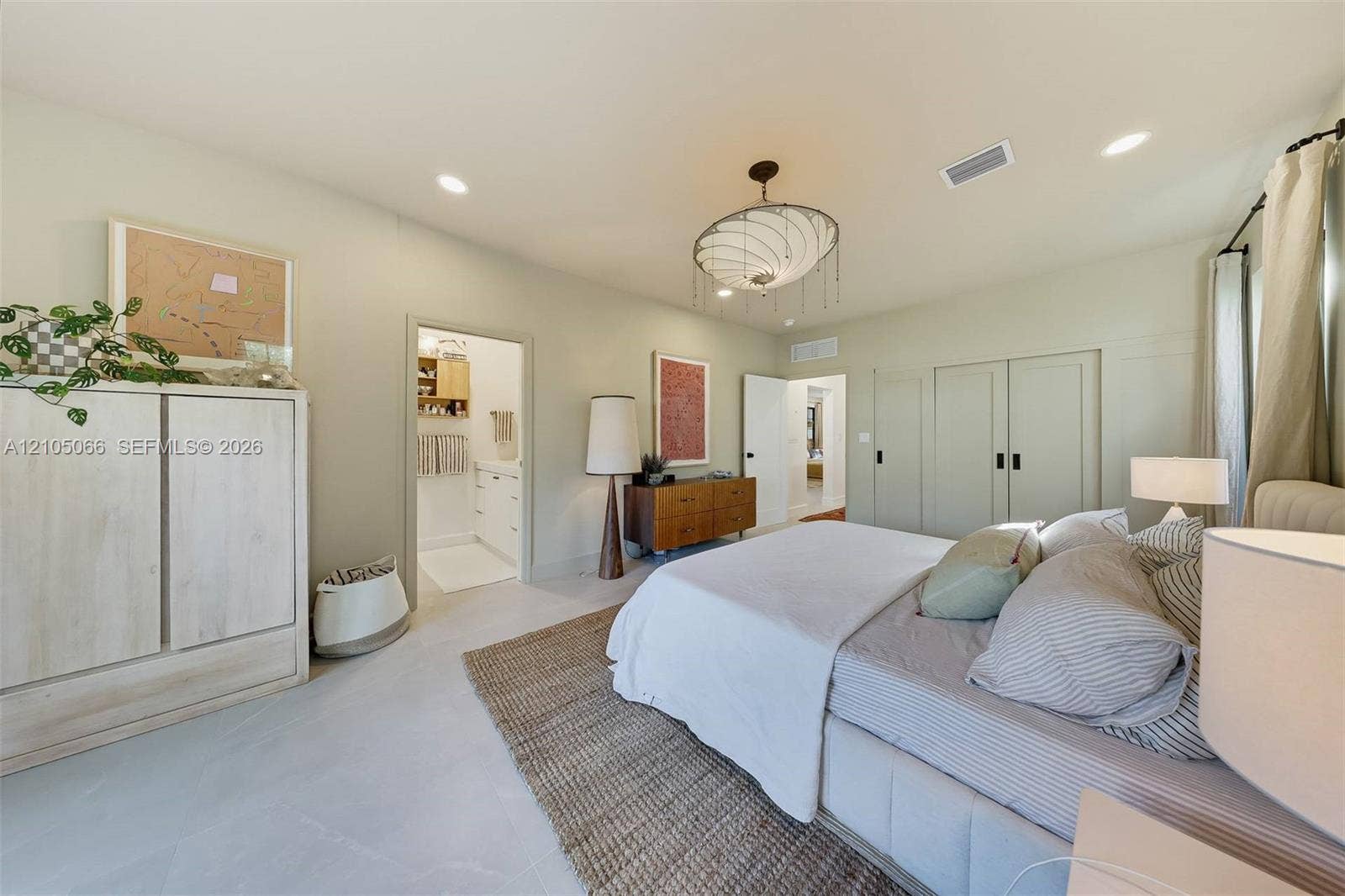 1230 Genoa Street, Coral Gables, Coral Gables, FL 33134 Bedroom featuring light-toned large-format tile flooring, recessed lighting, a modern multi-tiered chandelier, and floor-to-ceiling built-in cabinetry with matte black hardware