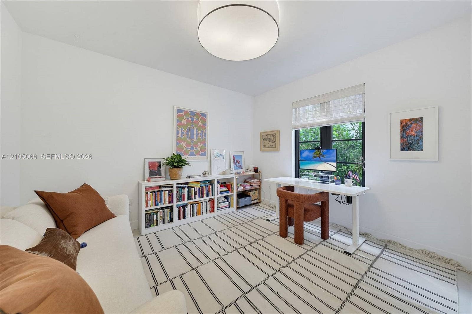1230 Genoa Street, Coral Gables, Coral Gables, FL 33134 Neutral-toned room featuring a drum-style flush mount ceiling light, a dark-framed multi-pane window, and a woven roller shade