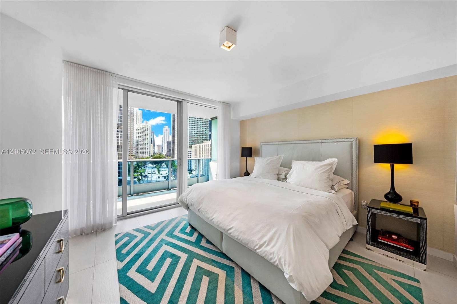 Floor-to-ceiling glass in the primary bedroom with Brickell skyline views beyond the upper terrace.