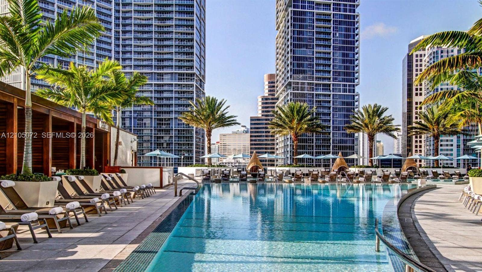 Hotel pool deck, open to residents, with lounge seating and city views.