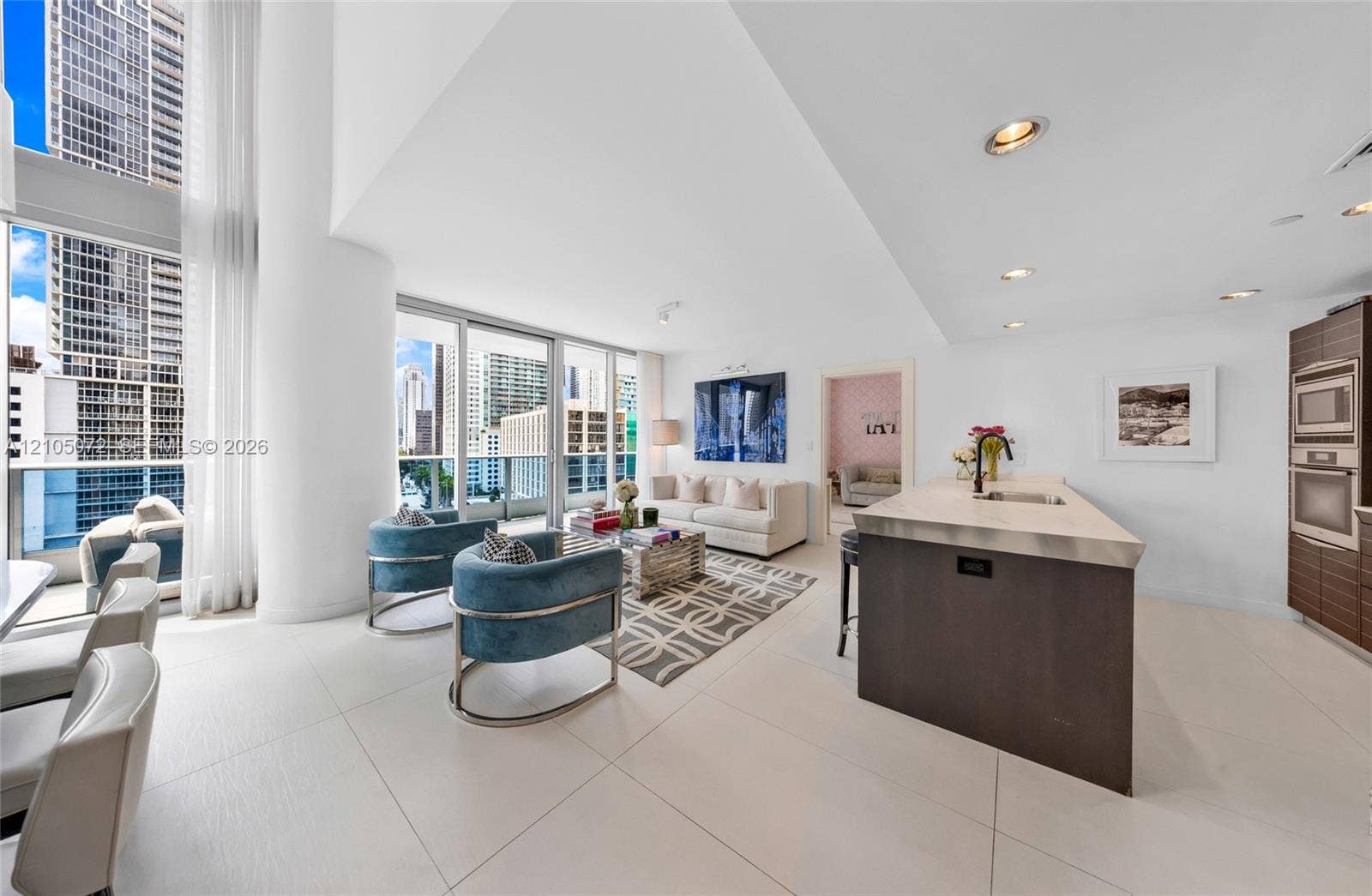 Open living and kitchen layout with Carrara marble island and floor-to-ceiling glass.