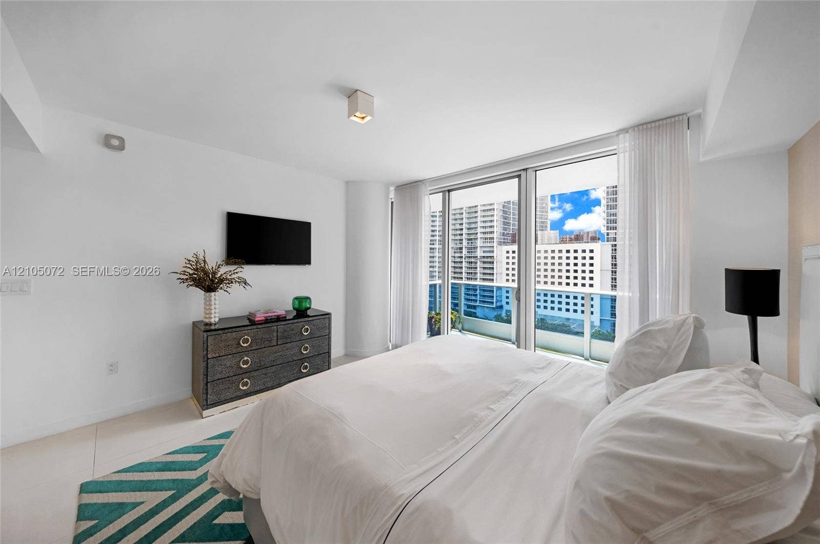 Primary bedroom with sliding glass doors connecting directly to the upper private terrace.