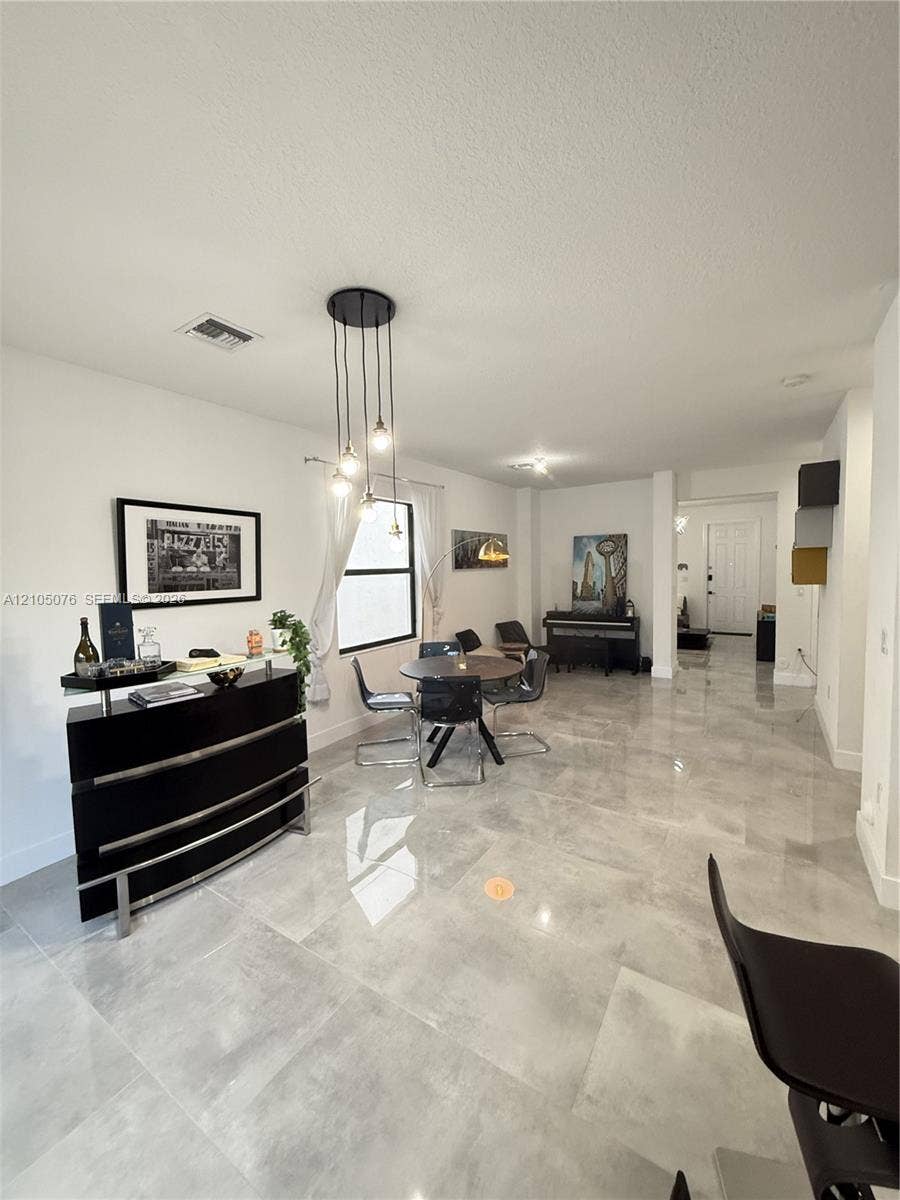 717 NE 191st Street, Miami, FL 33179 Large-format tile flooring, multi-light pendant fixture, and clean architectural lines