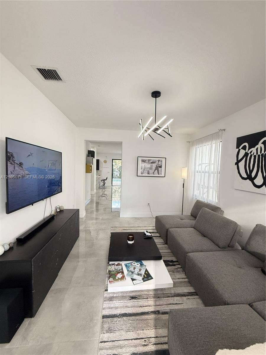 717 NE 191st Street, Miami, FL 33179 Polished tile flooring, modern multi-arm chandelier, and neutral wall finishes