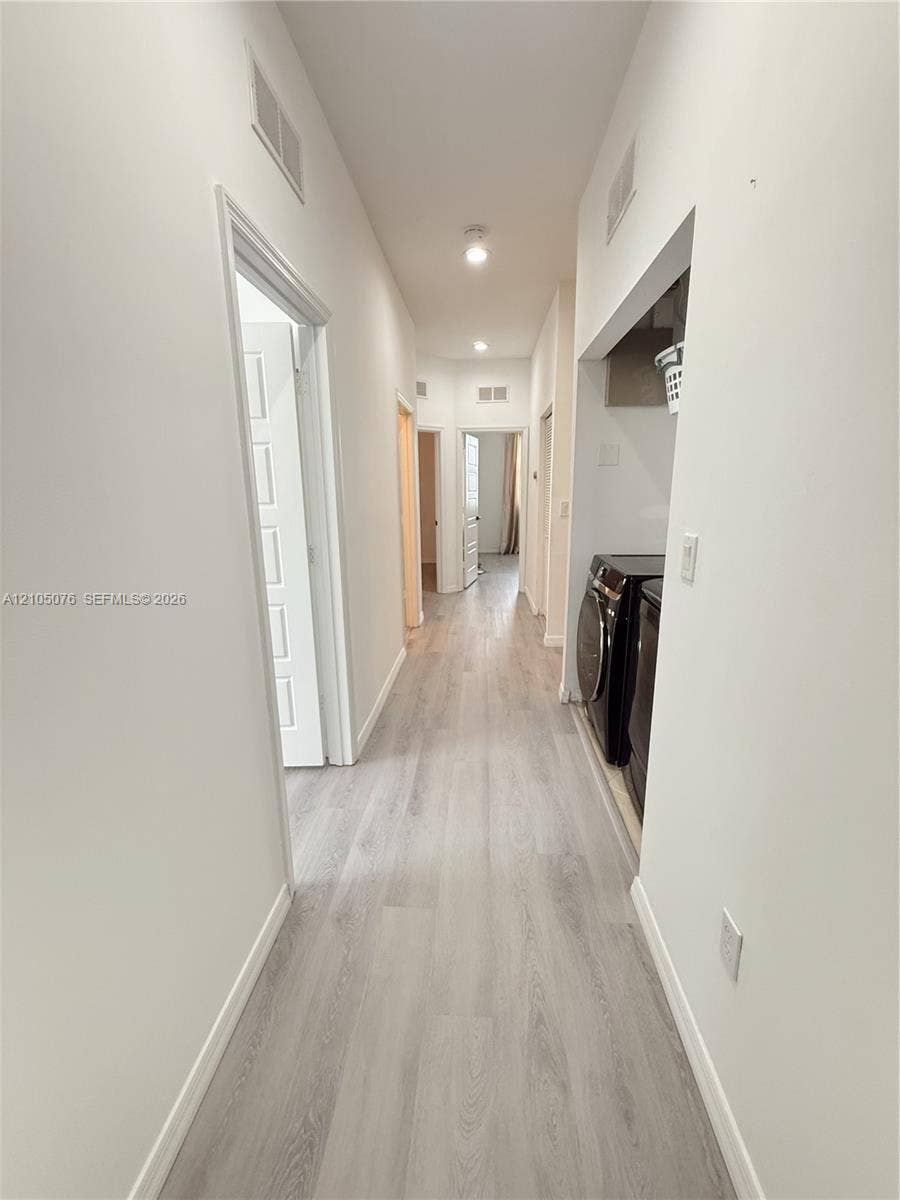 717 NE 191st Street, Miami, FL 33179 Hallway featuring wood-finish flooring, recessed ceiling lighting, and multiple panel doors