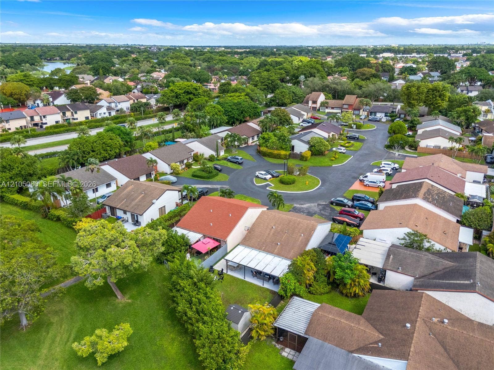 9755 SW 148th Court, Miami, FL 33196 Aerial perspective featuring residential structures with pitched rooflines, paved circular driveway infrastructure, and expansive green space