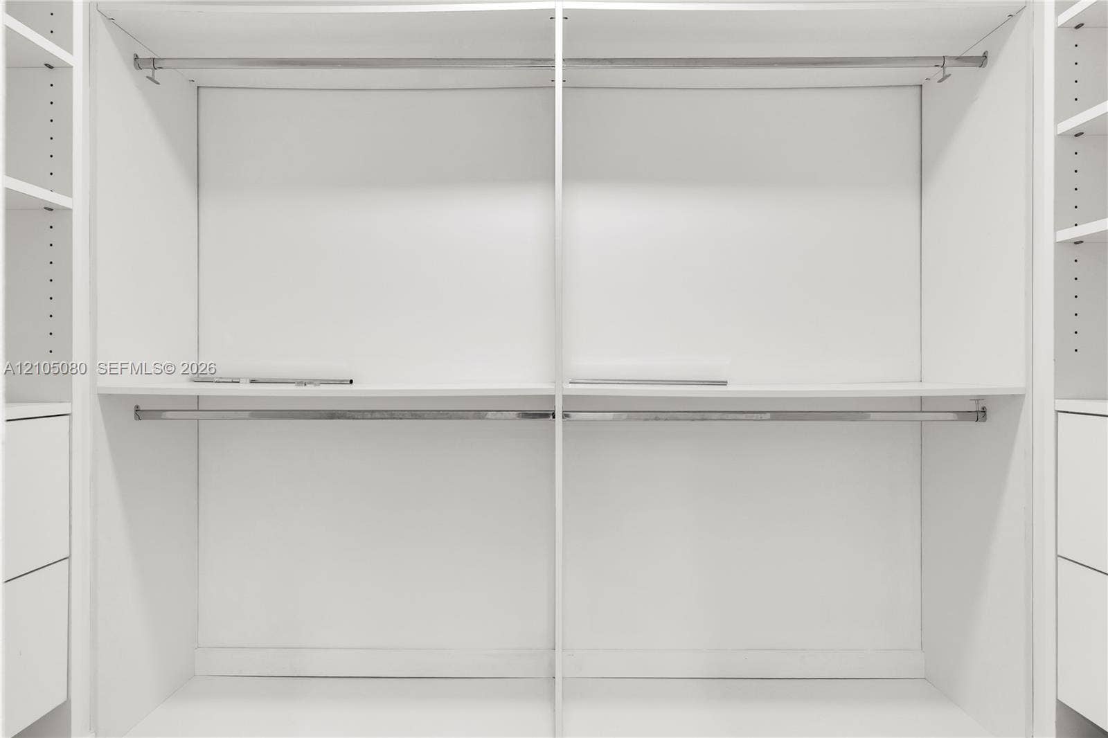 9755 SW 148th Court, Miami, FL 33196 Custom built-in closet organization system featuring white cabinetry, tiered hanging rods, adjustable shelving, and integrated drawer storage