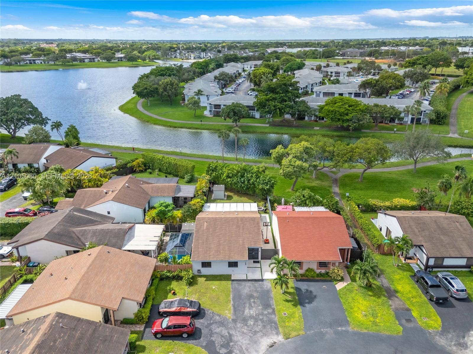 9755 SW 148th Court, Miami, FL 33196 Aerial perspective featuring asphalt driveways, manicured green space, and proximity to a community lake