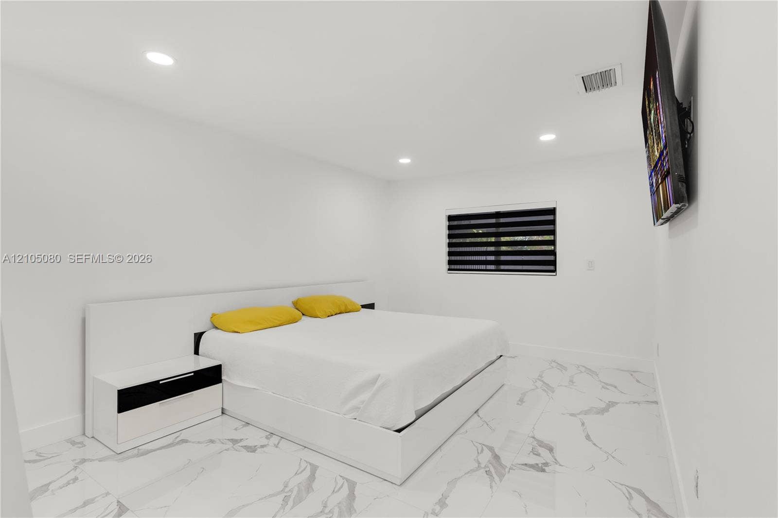 9755 SW 148th Court, Miami, FL 33196 Room featuring polished stone-look flooring, recessed ceiling lighting, and a window with dual-layer zebra roller shades