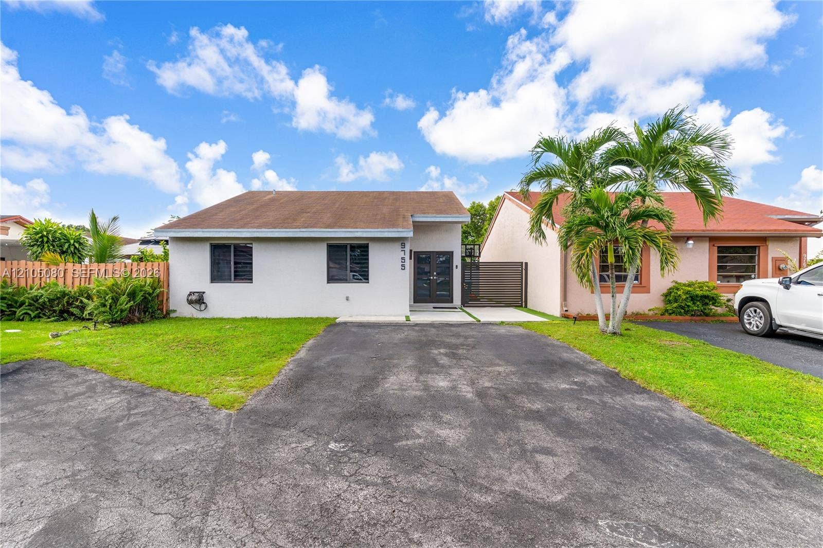 9755 SW 148th Court, Miami, FL 33196 Single-story exterior featuring a hip roof, dual-pane windows, a double-door entryway, and asphalt driveway