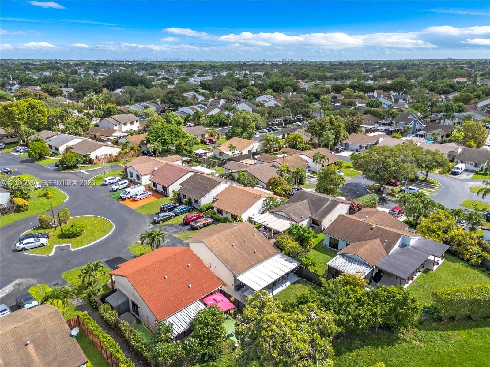 9755 SW 148th Court, Miami, FL 33196 Aerial perspective of a residential neighborhood featuring paved streets, mature trees, manicured lawns, and varied single-story rooflines