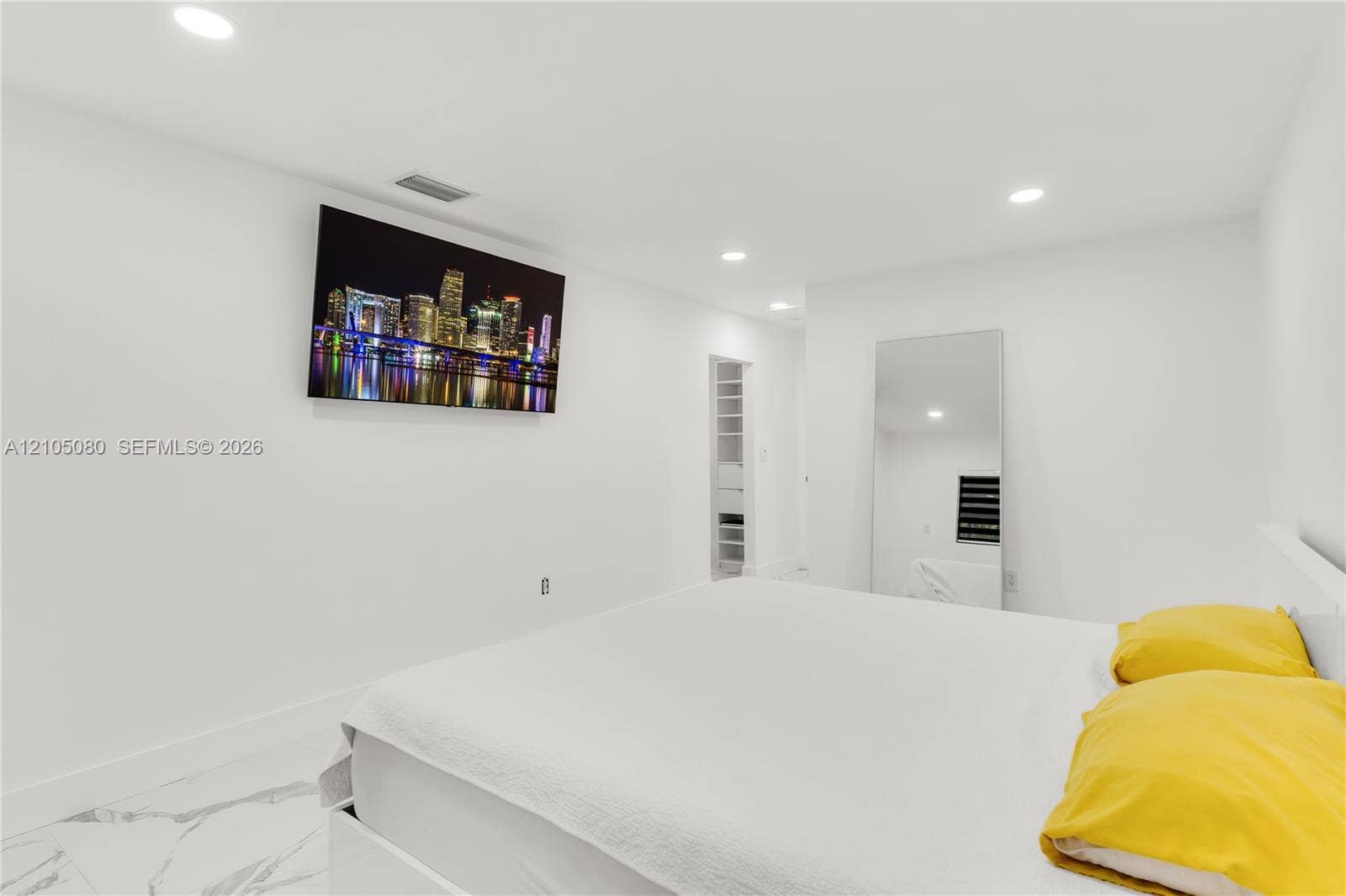 9755 SW 148th Court, Miami, FL 33196 Bright room interior featuring polished stone-finish flooring, recessed ceiling lighting, and a built-in reach-in closet with integrated shelving