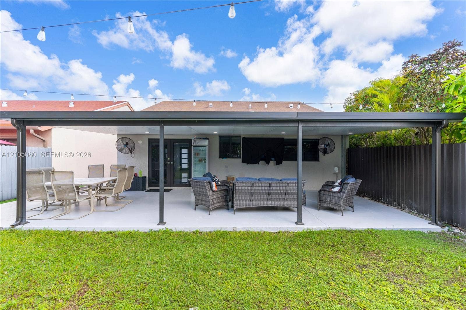 9755 SW 148th Court, Miami, FL 33196 Covered patio featuring a solid roof structure, painted concrete flooring, mounted wall fans, recessed lighting, and overhead string lighting