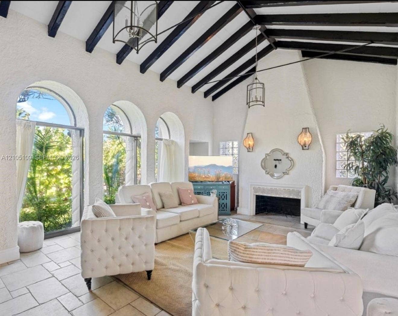 1134 Harrison Street, Hollywood, Hollywood, FL 33019 Vaulted ceilings with exposed beams, arched windows, stone tile flooring, and a built-in fireplace