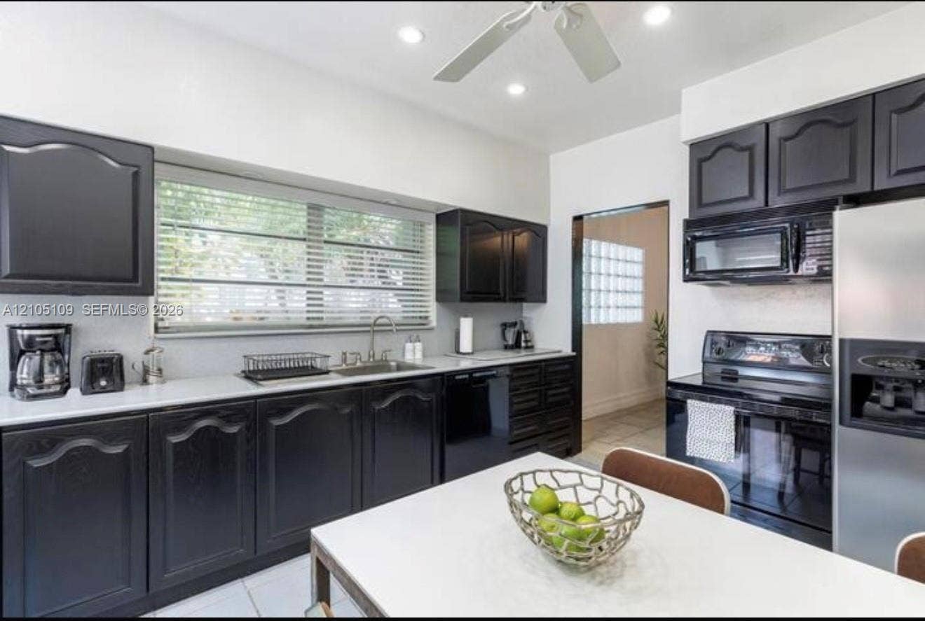1134 Harrison Street, Hollywood, Hollywood, FL 33019 Kitchen featuring black cabinetry, white countertops, stainless steel sink, a stainless steel refrigerator, and a built-in microwave