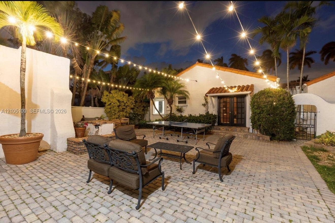 1134 Harrison Street, Hollywood, Hollywood, FL 33019 Paved patio featuring a stucco exterior, clay tile roof, and mature palm trees