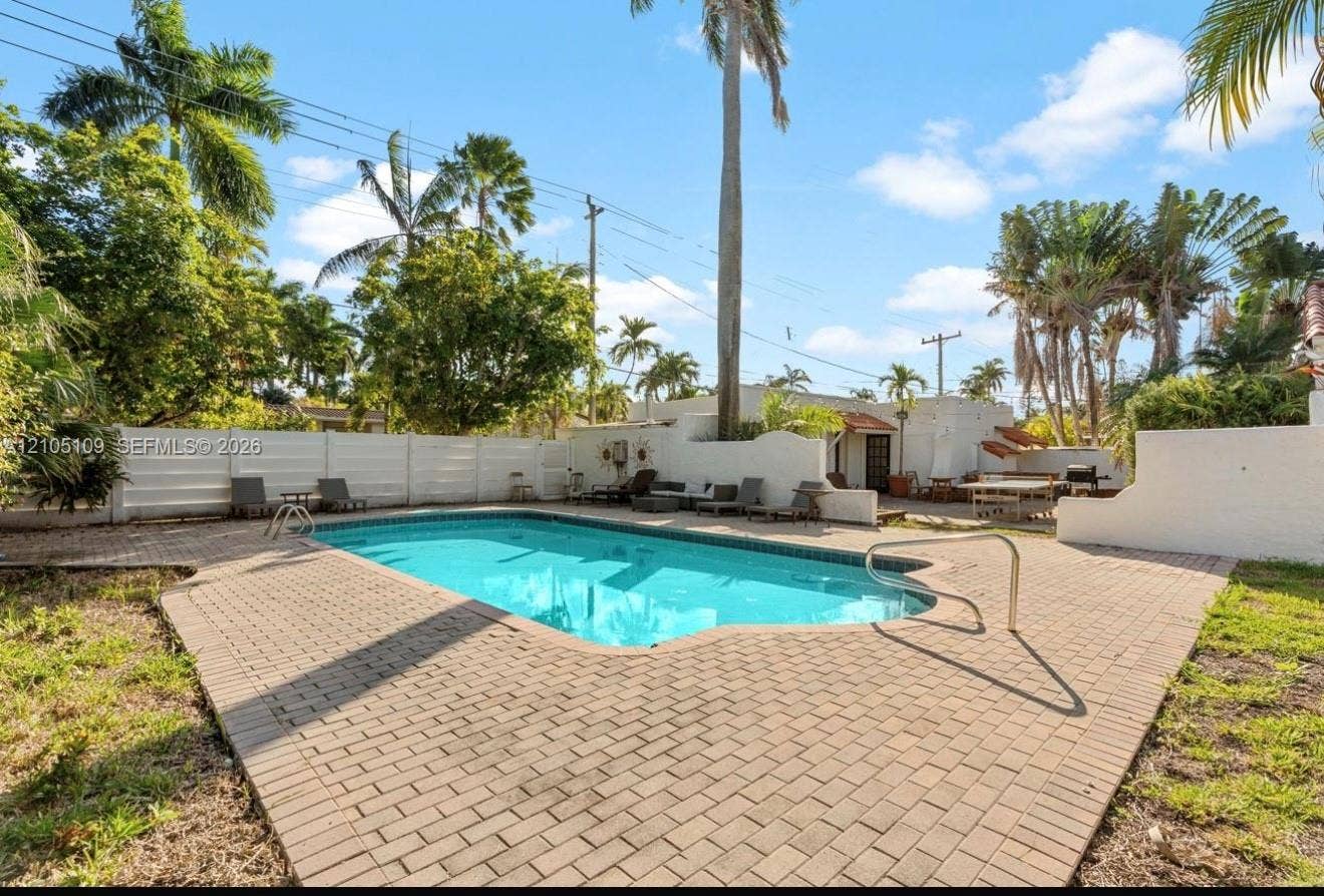 1134 Harrison Street, Hollywood, Hollywood, FL 33019 Swimming pool with brick paver surround, privacy fencing, and tropical landscaping