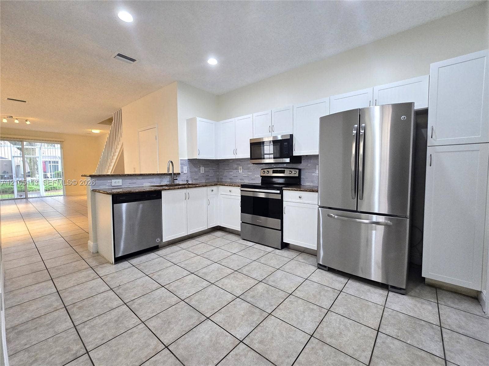2020 Pompeii Court, Weston, Weston, FL 33327 Kitchen featuring stainless steel appliances, white cabinetry, a tiled backsplash, and stone countertops