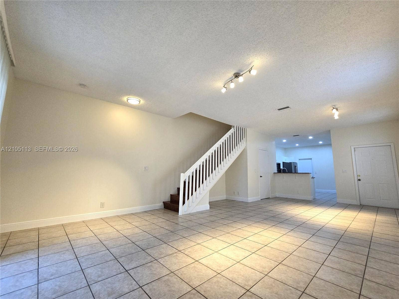 2020 Pompeii Court, Weston, Weston, FL 33327 Spacious open-concept living area featuring tile flooring, a white-railed staircase with wood-finish treads, and recessed lighting