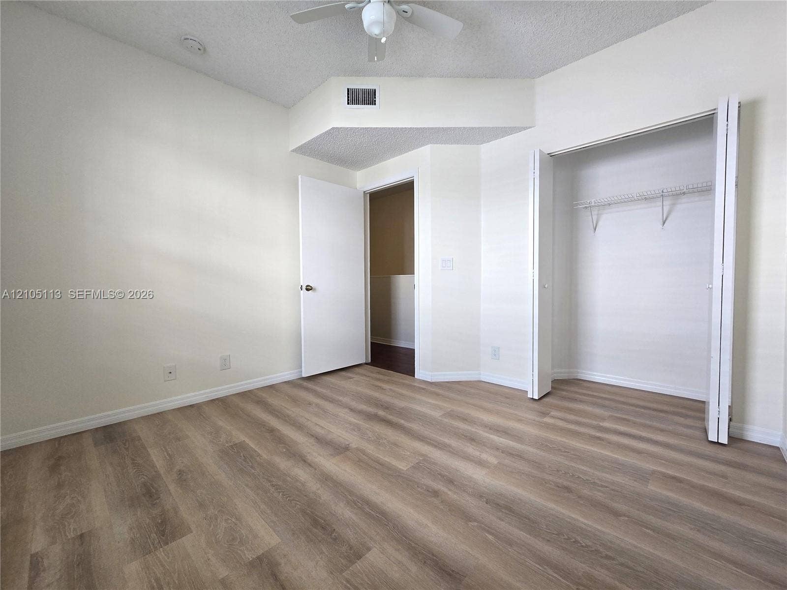 2020 Pompeii Court, Weston, Weston, FL 33327 Wood-finish flooring, white walls, ceiling fan, and bi-fold closet doors with wire shelving