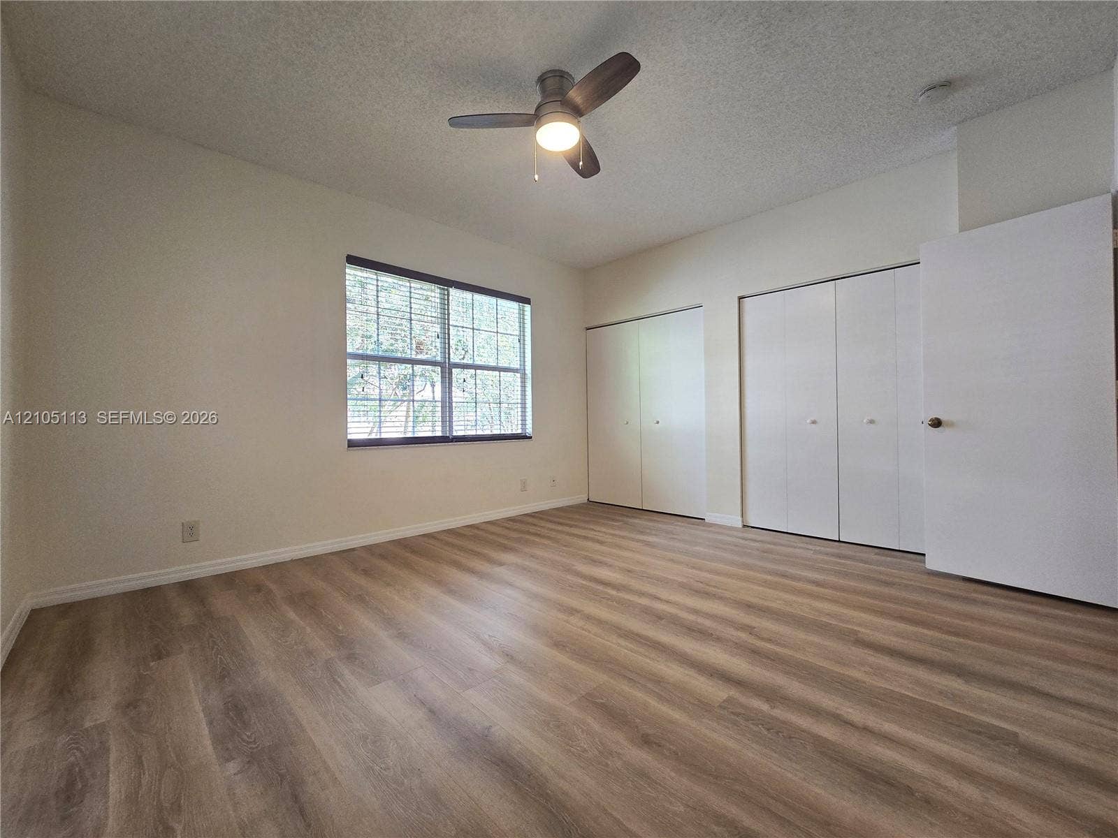 2020 Pompeii Court, Weston, Weston, FL 33327 Room featuring wood-finish flooring, a ceiling fan, and multiple bi-fold closet doors