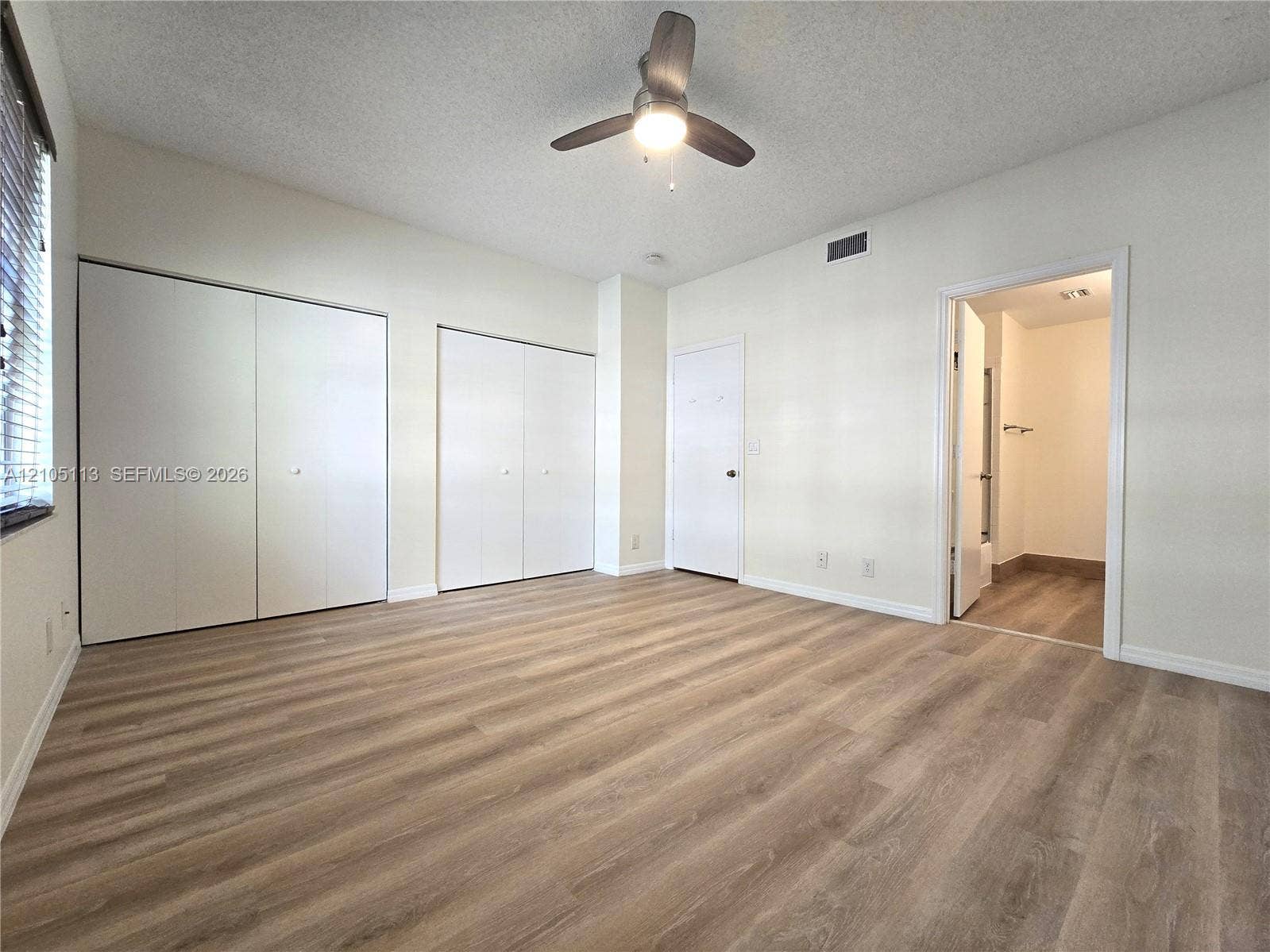 2020 Pompeii Court, Weston, Weston, FL 33327 Wood-finish flooring throughout, multiple bi-fold closet doors, ceiling fan with integrated lighting, and an entryway to an adjoining room