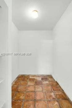 6851 SW 32nd Street, Miami, FL 33155 Enclosed space featuring square terra-cotta tile flooring, recessed wall shelving, and a dome-style ceiling light fixture