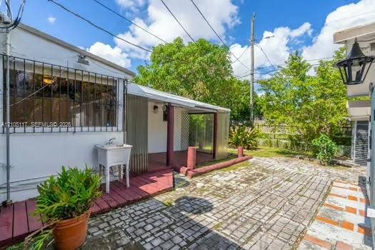 6851 SW 32nd Street, Miami, FL 33155 Exterior area featuring a paved stone patio, a covered wooden deck, and a utility sink