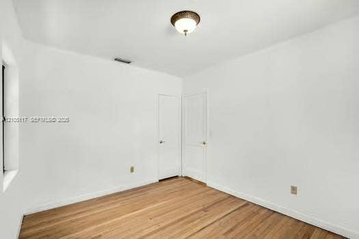 6851 SW 32nd Street, Miami, FL 33155 Room featuring wood-finish flooring, white walls, and a flush-mount ceiling light fixture
