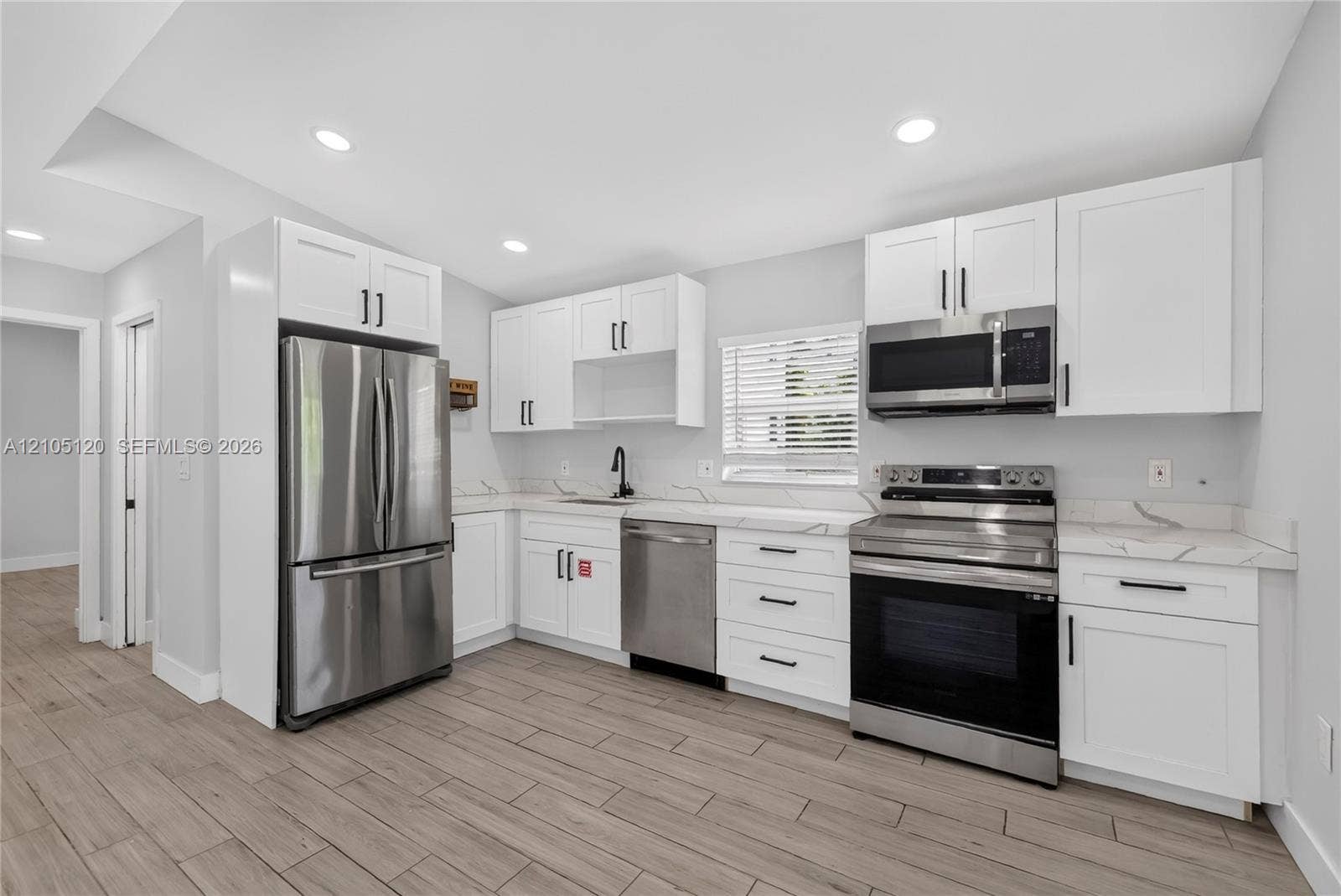 Fort Lauderdale, Fort Lauderdale, FL 33315 Kitchen featuring white shaker cabinetry, stainless steel appliances, stone-patterned countertops, recessed lighting, and wood-finish flooring