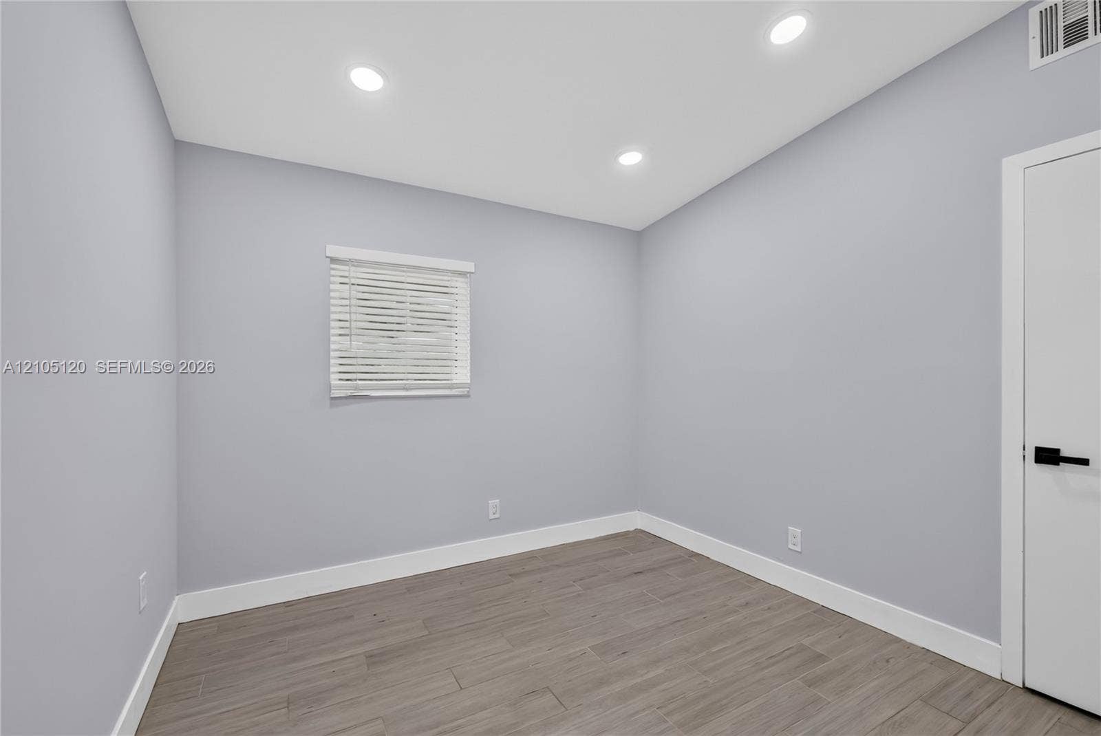 Fort Lauderdale, Fort Lauderdale, FL 33315 Neutral interior space featuring wood-finish tile flooring, recessed lighting, a single window with horizontal blinds, and a door with matte black hardware
