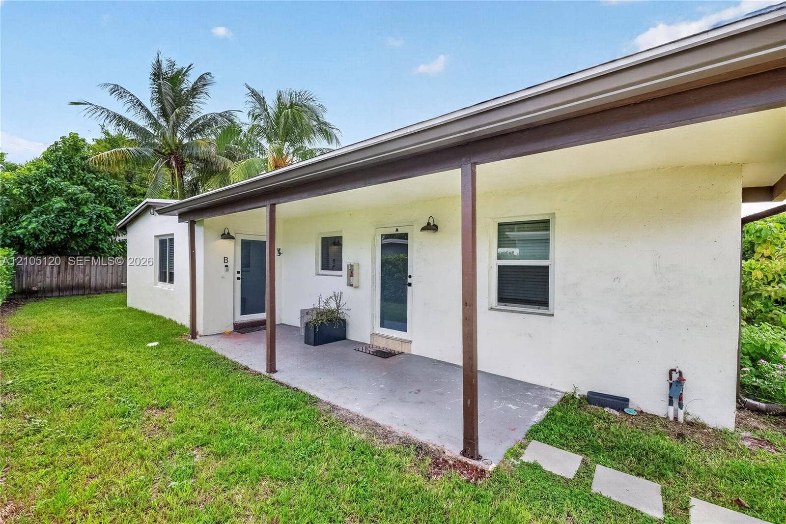 Fort Lauderdale, Fort Lauderdale, FL 33315 Covered patio featuring concrete flooring, structural support columns, dual exterior doors, and exterior wall-mounted lighting