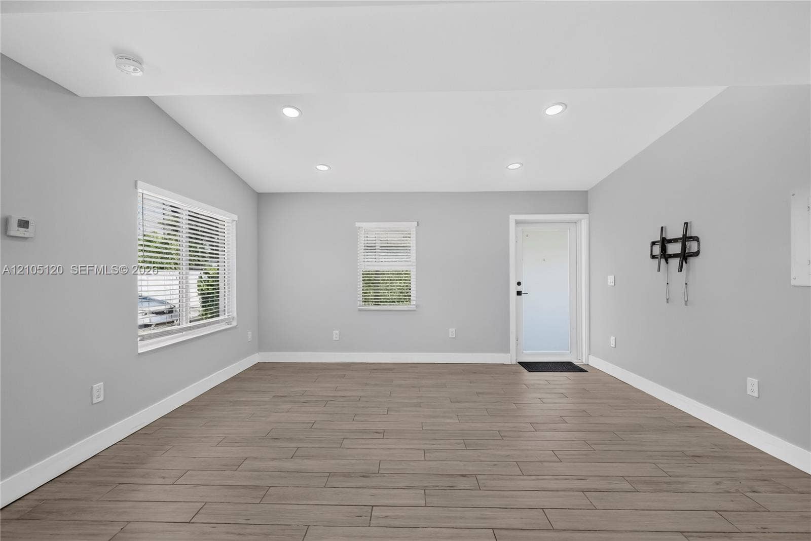 Fort Lauderdale, Fort Lauderdale, FL 33315 Neutral-toned interior featuring wood-finish tile flooring, recessed lighting, and multiple windows with white window blinds