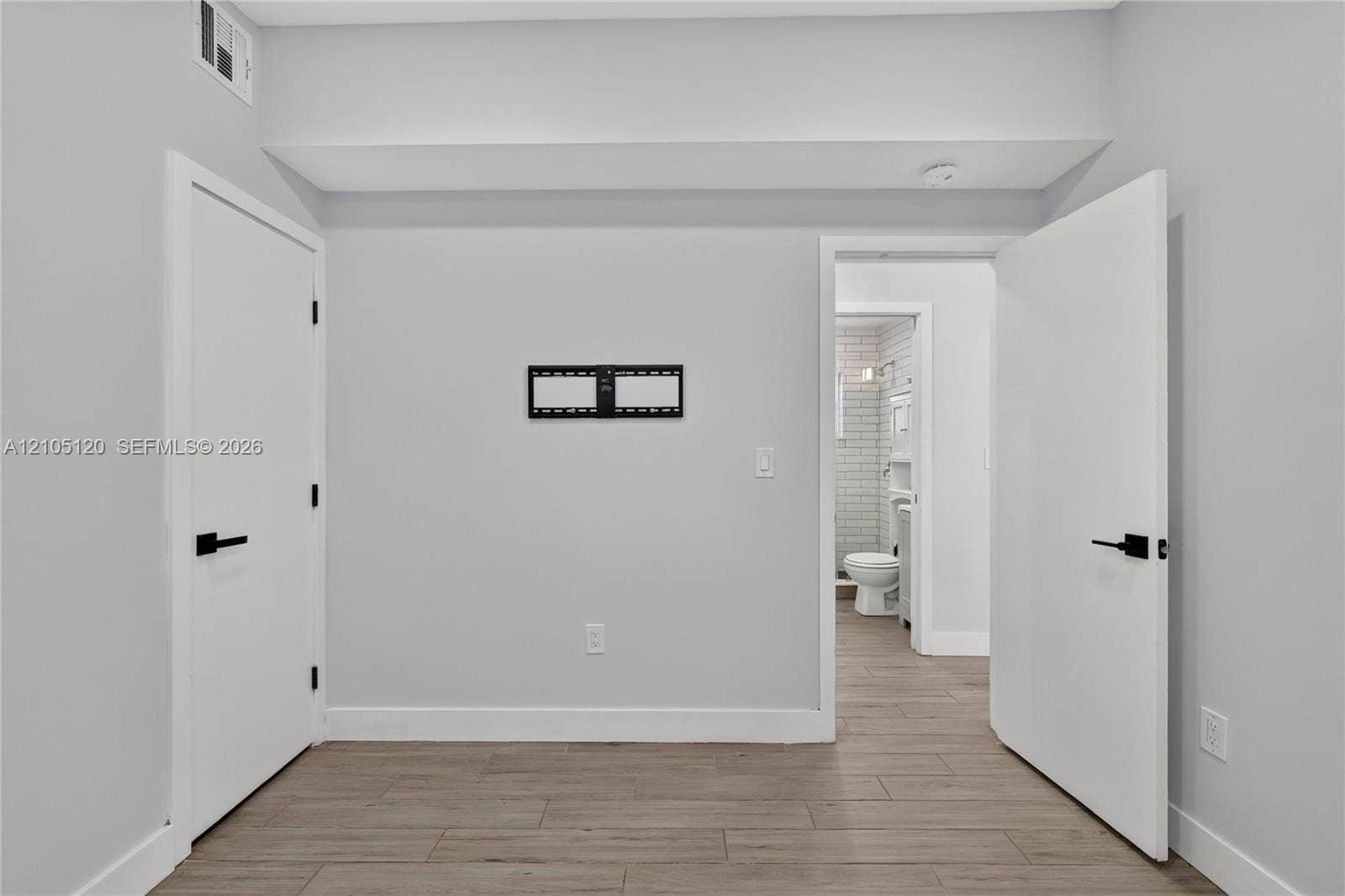 Fort Lauderdale, Fort Lauderdale, FL 33315 Interior space featuring wood-finish flooring, matte black door hardware, and smooth walls with neutral paint