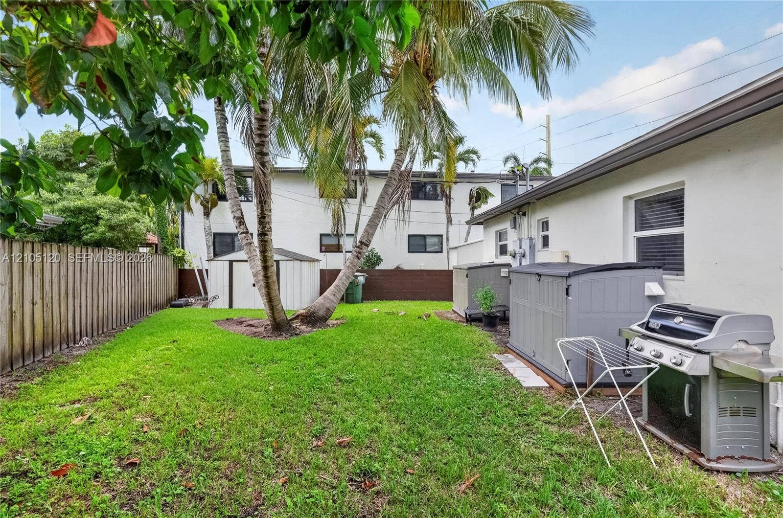 Fort Lauderdale, Fort Lauderdale, FL 33315 Fenced backyard featuring a manicured lawn, mature palm trees, and structural storage units