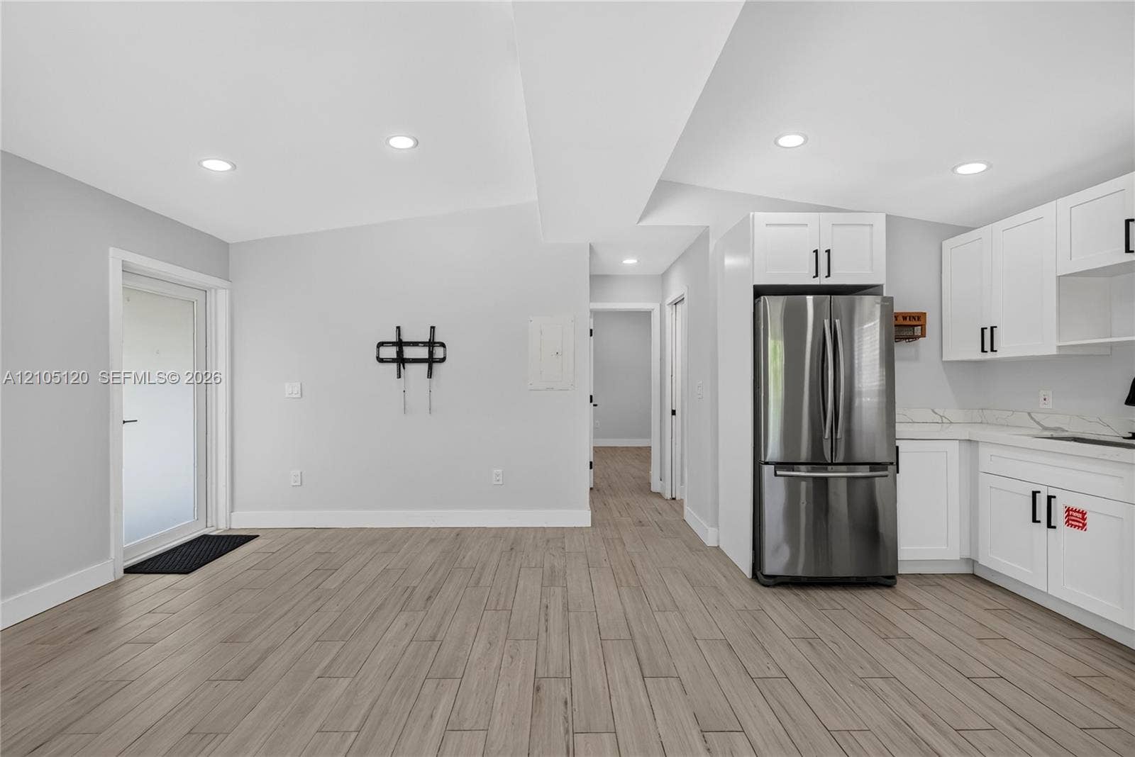 Fort Lauderdale, Fort Lauderdale, FL 33315 Wood-finish flooring, white shaker-style cabinetry, stainless steel refrigerator, stone-style countertops, and recessed lighting