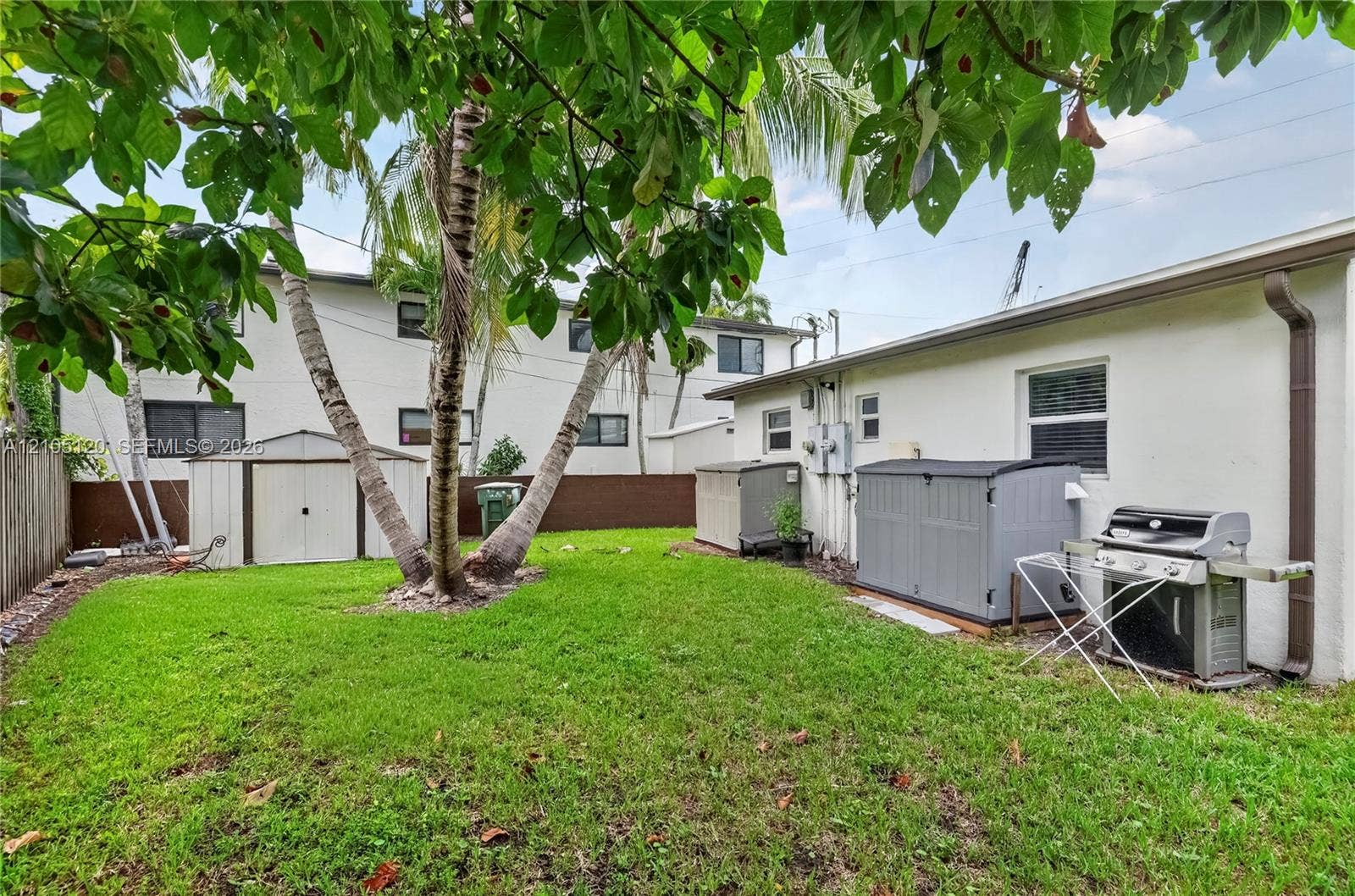 Fort Lauderdale, Fort Lauderdale, FL 33315 Backyard area featuring a manicured lawn, mature palm trees, and perimeter privacy fencing
